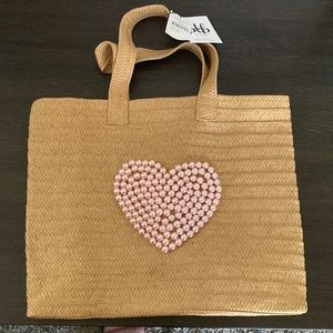 Straw bag with cute heart design. Lots of room. Has 1 pocket,